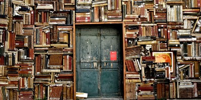 Doorway surrounded by stacks of book - Literature, Visual Culture and the Arts