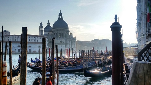 Gondolas in a canal with outline of church in Venice, Italy