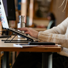 Student typing on a laptop at a library desk.