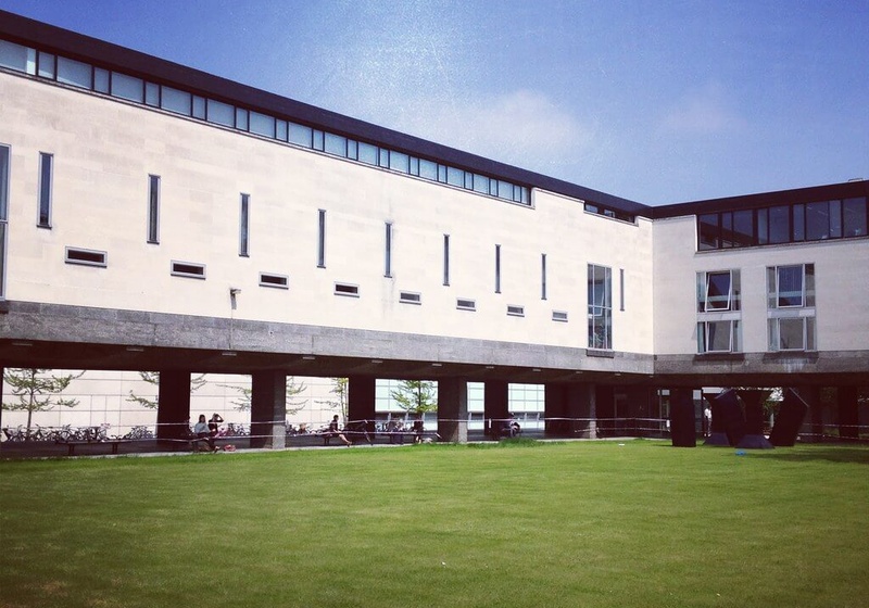 The Raised Faculty Building and the lawn beside it on a sunny day