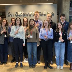 The organisers of the CUGS smiling and toasting at St Catharine's College.