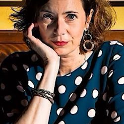 A picture of Eva Menasse facing the camera, looking serious, at a restaurant.