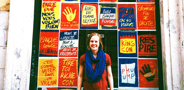 Student standing in front of French posters Student standing in front of French posters