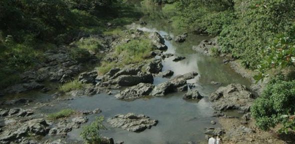 two met seemingly argue beside a shallow river. From the film Cocote